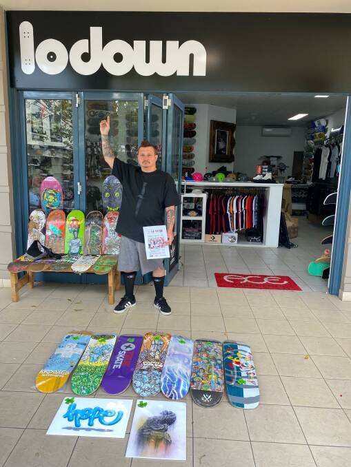 Legendary Cronulla skateboarder Jake Brown at the Cronulla Lodown skate shop with decks to be won in the orphanage raffle.