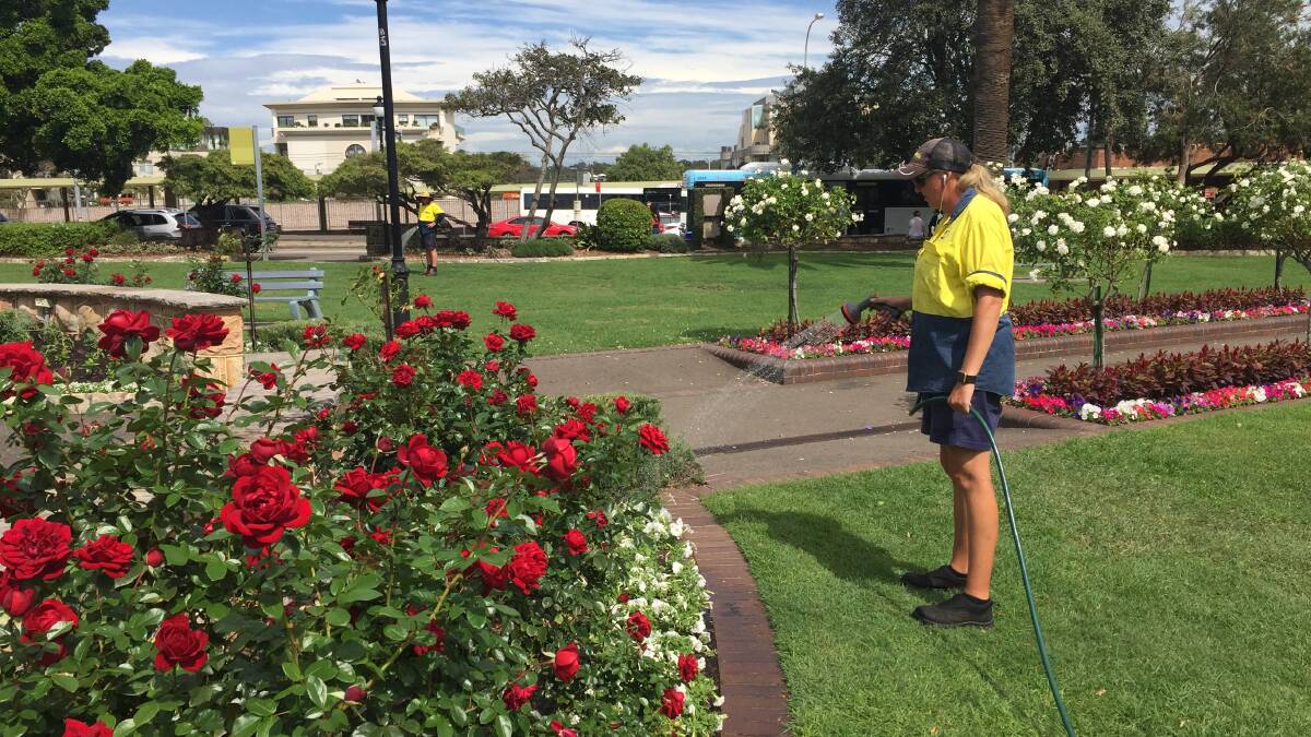 Smelling the roses: Council gardeners maintain the park's beauty while debate rages about the proposed adjoining hotel.