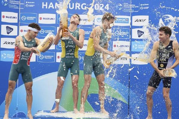 Australian triathletes Luke Willian and Matt Hauser (C) celebrate after their Hamburg race. (AP PHOTO)