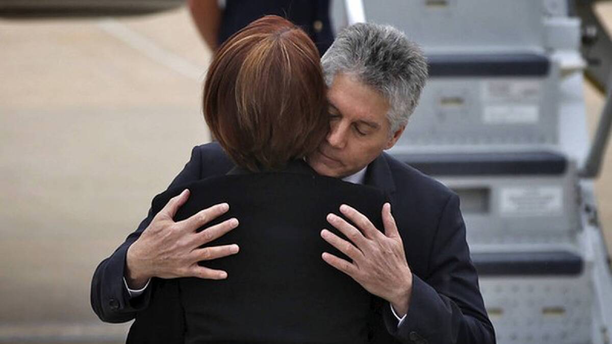 Prime Minister Julia Gillard is comforted by Defence Minister Stephen Smith following the sudden death of her father in September. Photo: Alex Ellinghausen