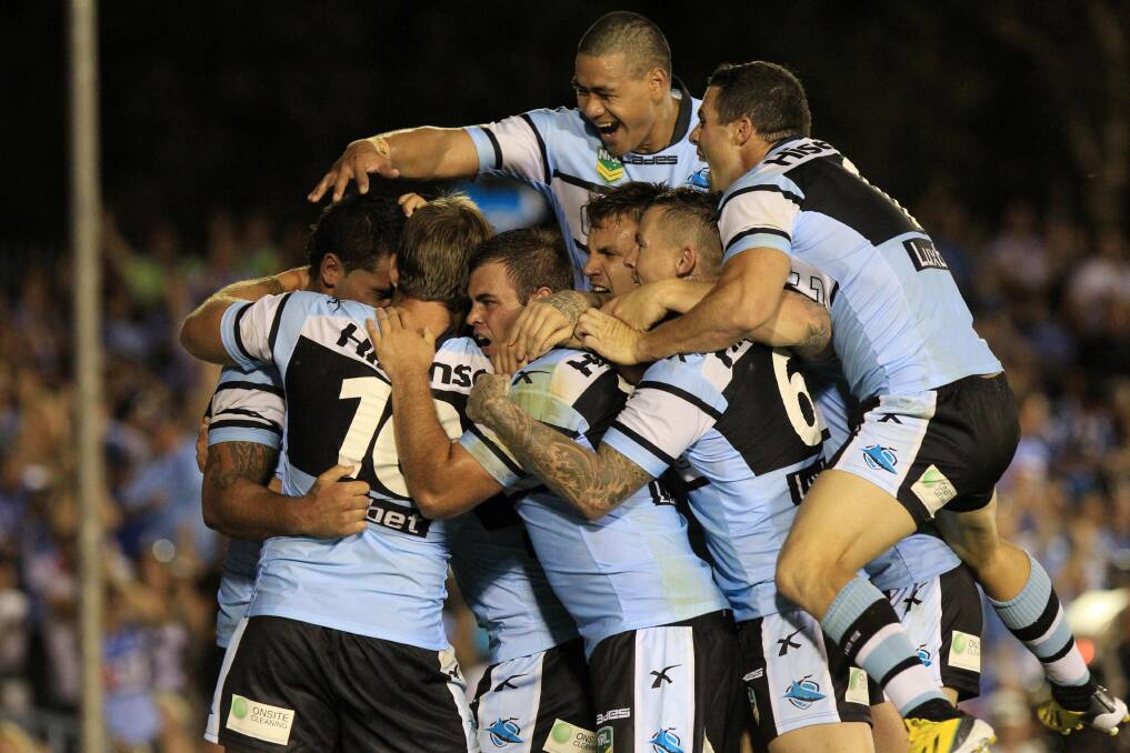 Pile it on: Sharks players celebrate the winning try by big Andrew Fifita (far left). Pictures: Chris Lane